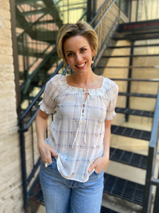 Elevate your style game with the Neville White Plaid Pattern Blouse. Its charming plaid design, complete with a playful split tie neck, offers the perfect blend of comfort and flair. Whether you're off to brunch or a casual day out, this lightweight smocked blouse ensures you look fabulous all day long.

- Classic plaid pattern for a timeless vibe
- Fun split tie neck for added style
- Lightweight smocked fabric for all-day comfort
- Pairs effortlessly with any outfit
- Composition: 63% rayon, 37% polyester