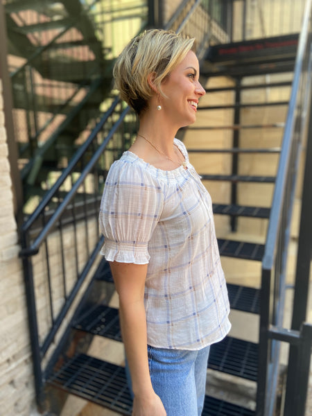 Elevate your style game with the Neville White Plaid Pattern Blouse. Its charming plaid design, complete with a playful split tie neck, offers the perfect blend of comfort and flair. Whether you're off to brunch or a casual day out, this lightweight smocked blouse ensures you look fabulous all day long.

- Classic plaid pattern for a timeless vibe
- Fun split tie neck for added style
- Lightweight smocked fabric for all-day comfort
- Pairs effortlessly with any outfit
- Composition: 63% rayon, 37% polyester