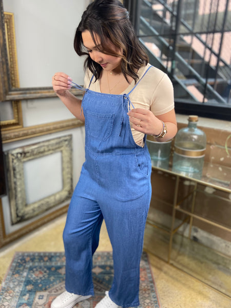 light blue denim overalls jumpsuit pockets long wide leg spaghetti straps side view