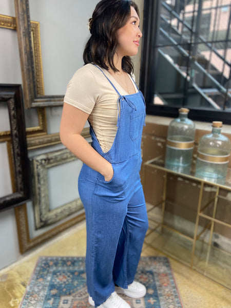 light blue denim overalls jumpsuit pockets long wide leg spaghetti straps side view