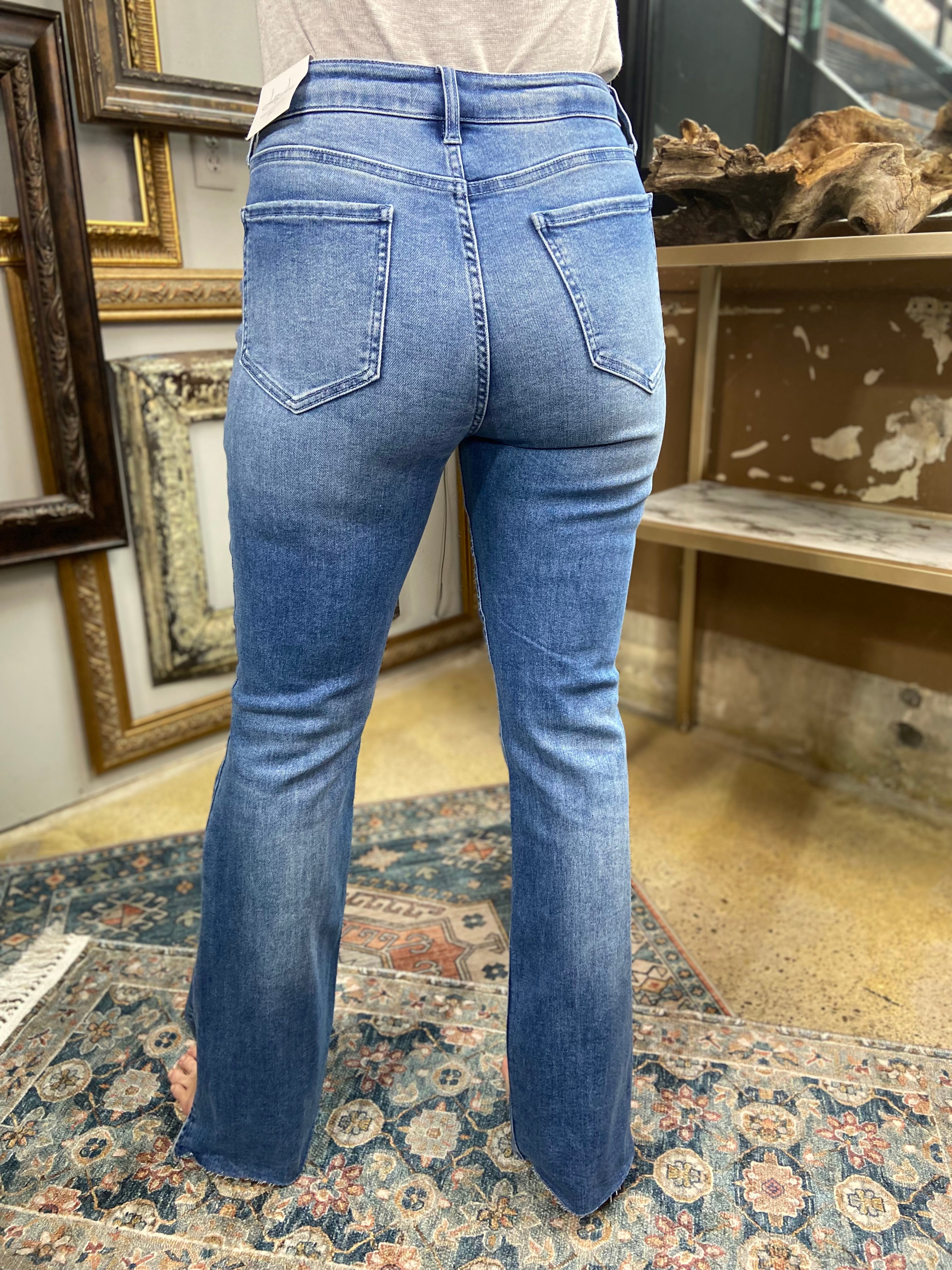 jelly jeans flare dark to medium wash side slit raw hem solid high waisted mid rise jeans paired with gray long sleeve