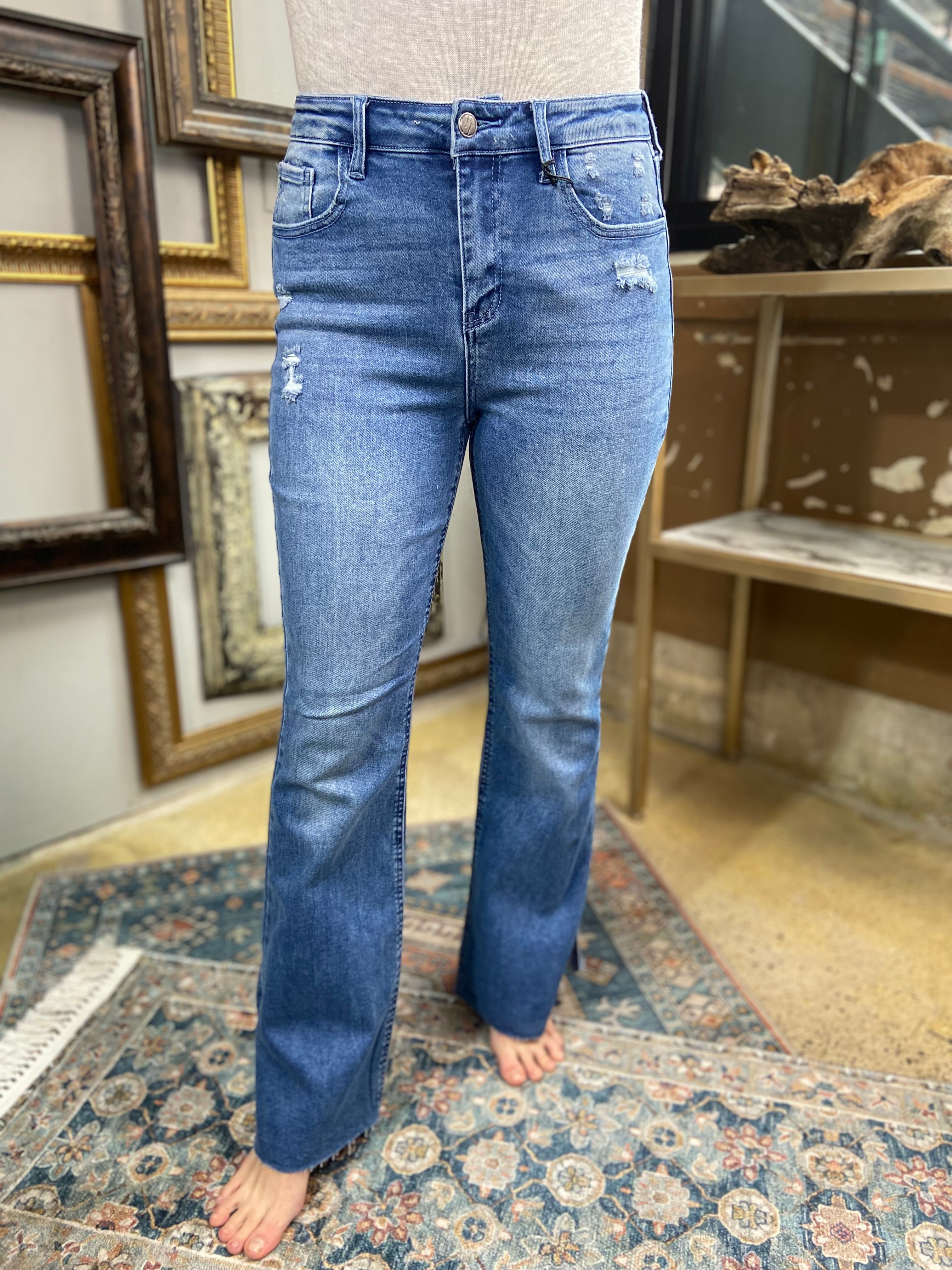 jelly jeans flare dark to medium wash side slit raw hem solid high waisted mid rise jeans paired with gray long sleeve