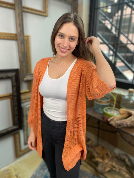 orange mesh cardigan light comfortable cover up paired with black jeans and white tank top