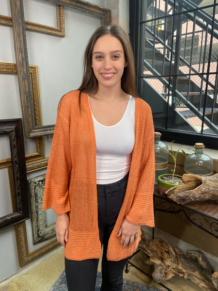 orange mesh cardigan light comfortable cover up paired with black jeans and white tank top