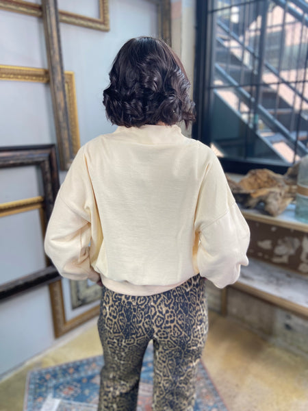 oversized quarter half zip cream sweater paired with leopard pants back view